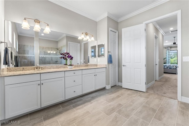 bathroom with double vanity, an inviting chandelier, ornamental molding, tiled shower, and a sink