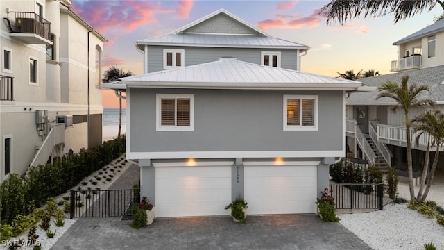 26628 Hickory Blvd, Bonita Springs, FL 34134 - coastal inspired home featuring a garage, driveway, a metal roof, and stucco siding