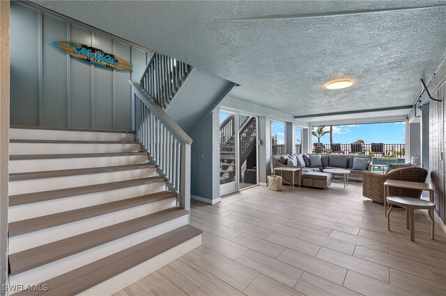26628 Hickory Blvd, Bonita Springs, FL 34134 - stairs featuring a textured ceiling and wood finished floors