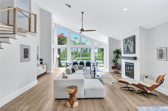 27571 Riverbank Dr, Bonita Springs, FL 34134 - living area featuring visible vents, baseboards, a ceiling fan, light wood-style flooring, and a glass covered fireplace