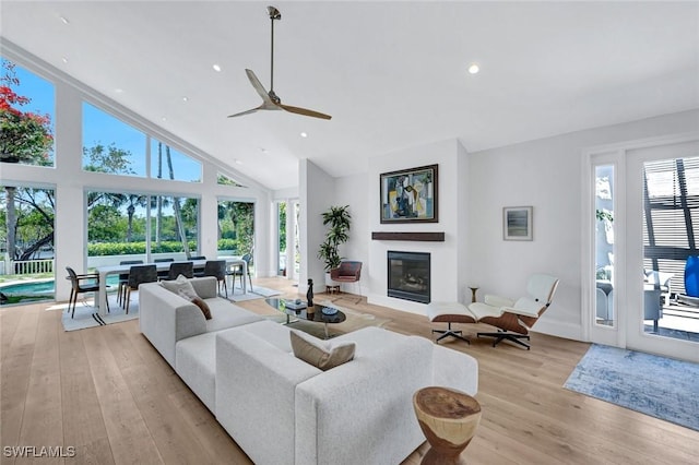 27571 Riverbank Dr, Bonita Springs, FL 34134 - living area with ceiling fan, recessed lighting, light wood-style flooring, high vaulted ceiling, and a glass covered fireplace