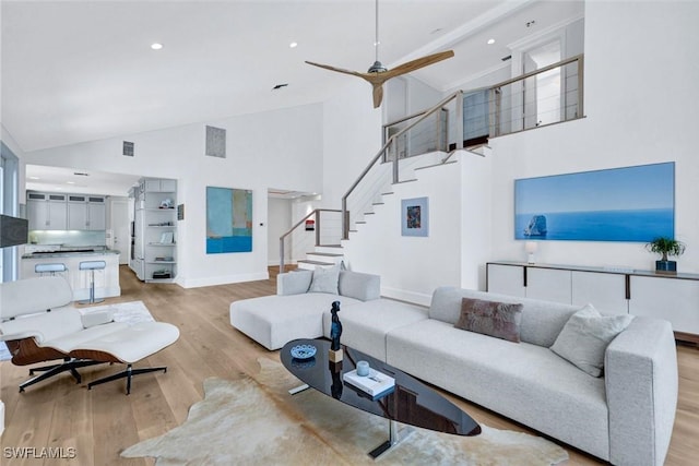27571 Riverbank Dr, Bonita Springs, FL 34134 - living room with high vaulted ceiling, ceiling fan, stairway, light wood finished floors, and baseboards