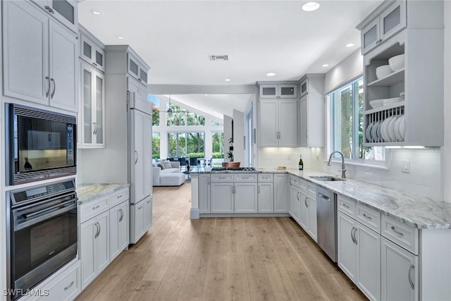 27571 Riverbank Dr, Bonita Springs, FL 34134 - kitchen with visible vents, black appliances, a sink, lofted ceiling, and decorative backsplash
