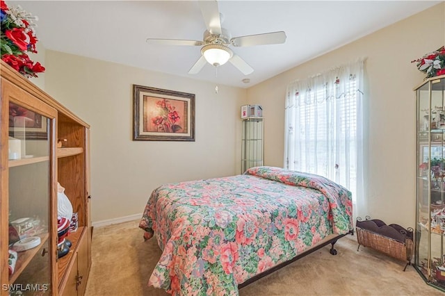 carpeted bedroom featuring a ceiling fan and baseboards