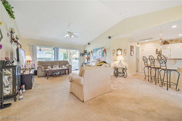 living room featuring light carpet, baseboards, lofted ceiling, and ceiling fan