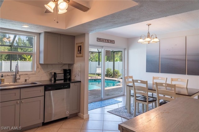 kitchen featuring gray cabinetry, a sink, a healthy amount of sunlight, and stainless steel dishwasher
