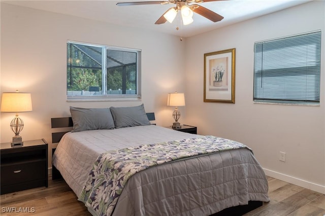 bedroom with baseboards, wood finished floors, and ceiling fan