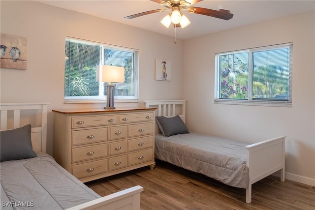 bedroom with a ceiling fan, baseboards, and wood finished floors