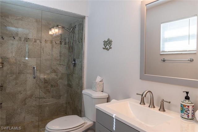 bathroom with a stall shower, toilet, and vanity