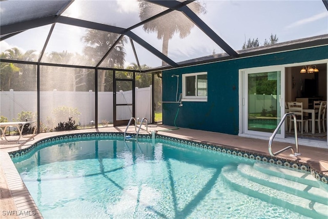 view of swimming pool featuring a patio, fence, a fenced in pool, and a lanai