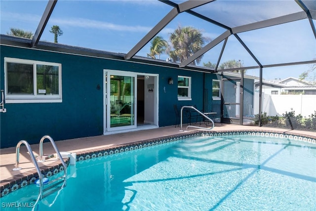 pool with a lanai, fence, and a patio area