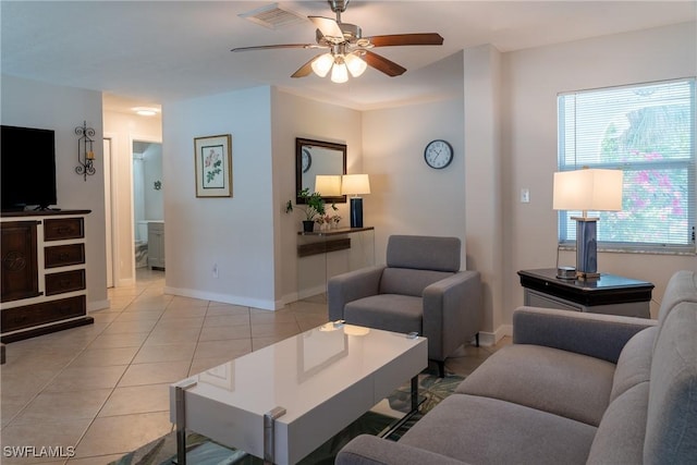 living room with baseboards, a ceiling fan, visible vents, and light tile patterned floors