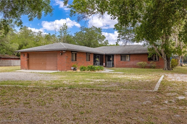 310 Trader Rd, Fort Denaud, FL 33935 - ranch-style home with driveway, a front yard, an attached garage, and brick siding