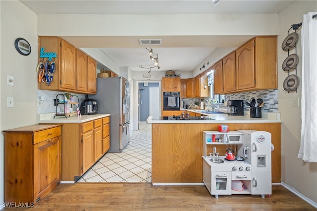 310 Trader Rd, Fort Denaud, FL 33935 - kitchen with backsplash, a peninsula, brown cabinetry, visible vents, and oven