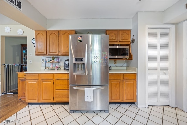 310 Trader Rd, Fort Denaud, FL 33935 - kitchen featuring light countertops, brown cabinetry, light tile patterned floors, and appliances with stainless steel finishes