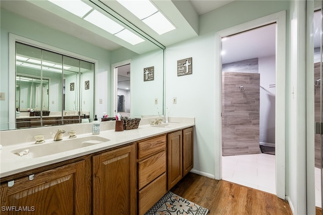310 Trader Rd, Fort Denaud, FL 33935 - full bathroom with double vanity, a sink, tiled shower, and wood finished floors