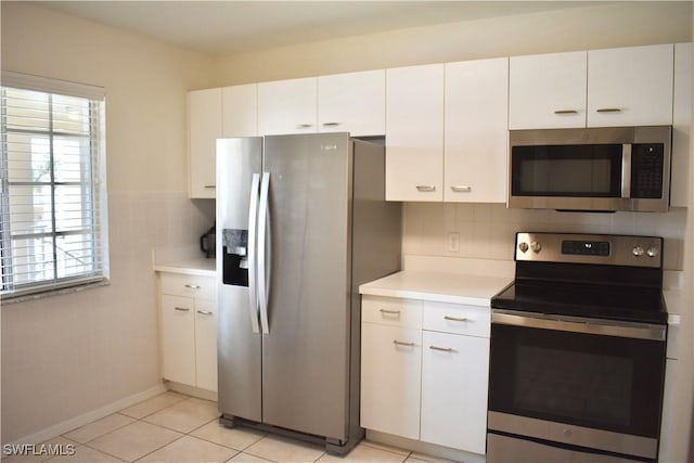 kitchen featuring white cabinets, light countertops, light tile patterned flooring, and appliances with stainless steel finishes