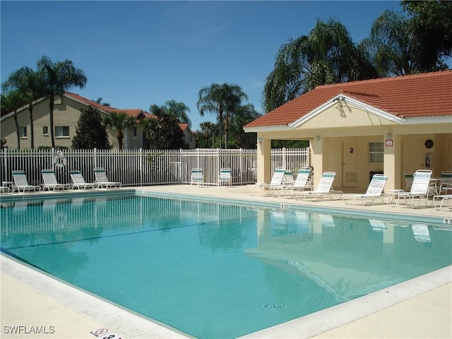 pool with a patio area and fence