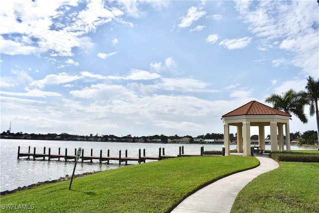 view of dock with a water view, a gazebo, and a lawn