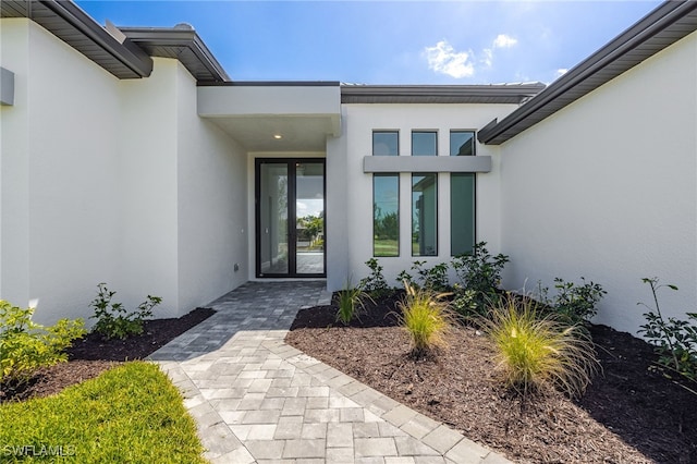 view of exterior entry with stucco siding
