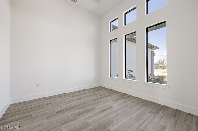empty room featuring baseboards and light wood-style flooring