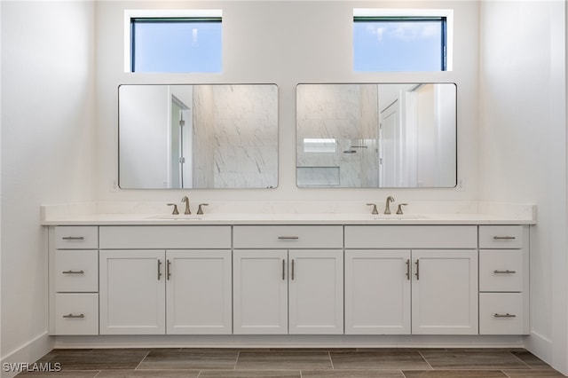 full bathroom featuring a wealth of natural light, a sink, and baseboards