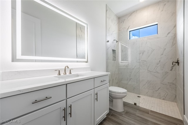 bathroom with toilet, walk in shower, vanity, and wood finished floors