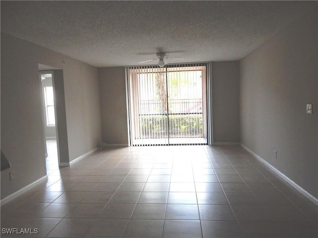 13621 Eagle Ridge Dr Unit 1518, Fort Myers, FL 33912 - tiled spare room featuring a textured ceiling, ceiling fan, and baseboards