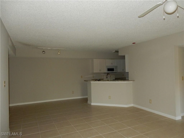 13621 Eagle Ridge Dr Unit 1518, Fort Myers, FL 33912 - unfurnished living room featuring baseboards, a textured ceiling, a sink, and a ceiling fan