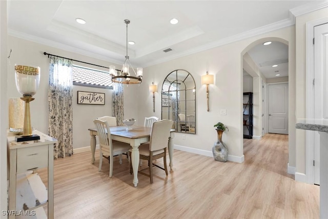 3260 Miyagi Ln, Naples, FL 34114 - dining space with a tray ceiling, light wood-type flooring, arched walkways, and ornamental molding