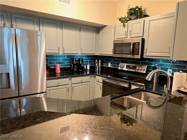 15585 Ocean Walk Cir Unit 216, Fort Myers, FL 33908 - kitchen featuring stainless steel appliances, backsplash, and dark stone countertops