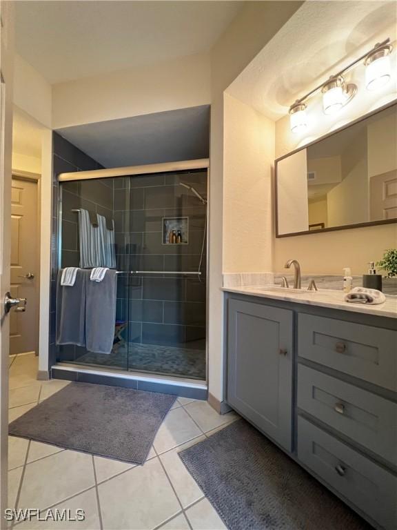15585 Ocean Walk Cir Unit 216, Fort Myers, FL 33908 - full bathroom featuring vanity, a stall shower, and tile patterned flooring