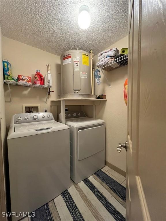 15585 Ocean Walk Cir Unit 216, Fort Myers, FL 33908 - laundry room with washer and dryer, water heater, and a textured ceiling