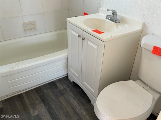 1308 Brookhill Dr, Fort Myers, FL 33916 - full bathroom featuring a bath, wood finished floors, toilet, vanity, and a textured wall