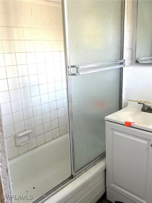 1308 Brookhill Dr, Fort Myers, FL 33916 - full bath featuring vanity, a textured wall, and bath / shower combo with glass door