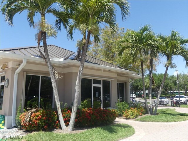 exterior space featuring stucco siding, a standing seam roof, and metal roof