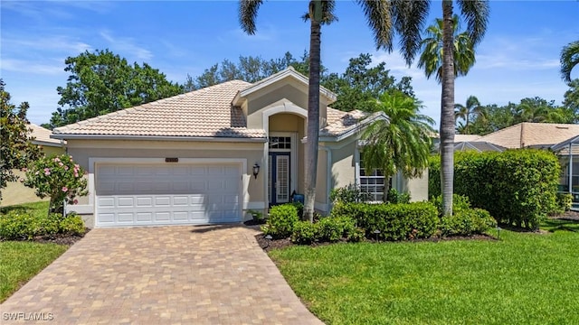 single story home with a garage, a front yard, stucco siding, and decorative driveway