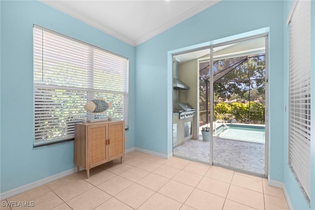 doorway to outside featuring baseboards, crown molding, and plenty of natural light