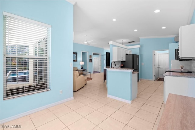 kitchen featuring light tile patterned floors, white cabinetry, baseboards, ornamental molding, and freestanding refrigerator