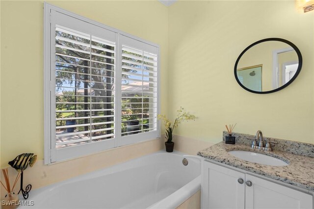 bathroom featuring a garden tub and vanity