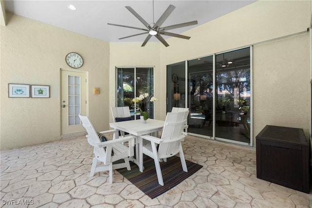dining room with a ceiling fan and stone flooring