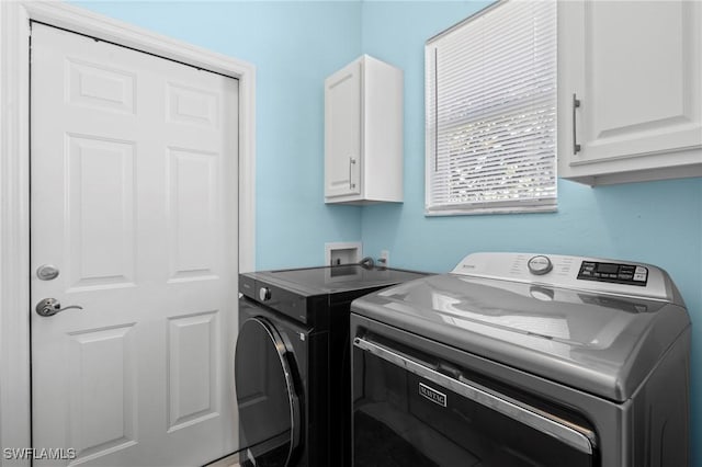 washroom featuring cabinet space and independent washer and dryer