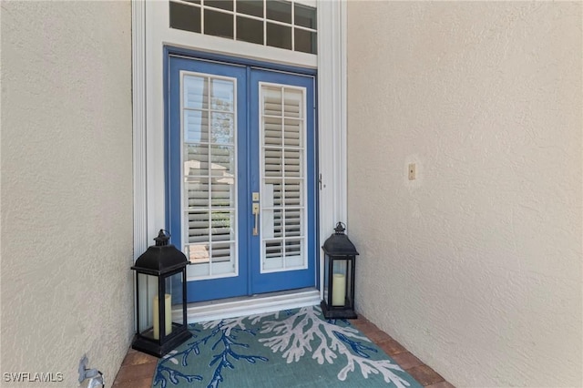 doorway to property featuring french doors and stucco siding