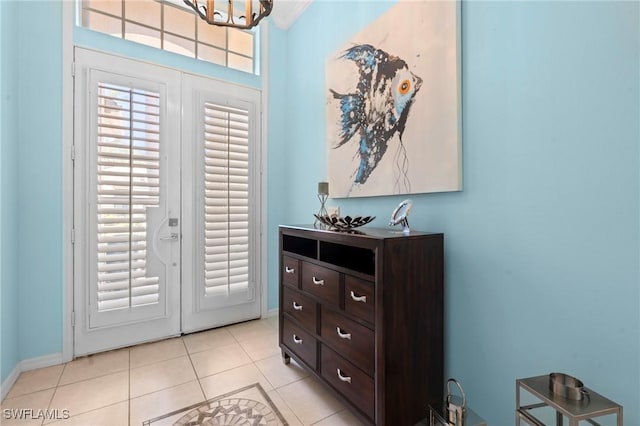 interior space featuring baseboards, a chandelier, and light tile patterned floors