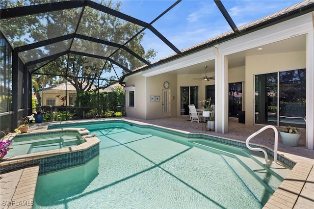 view of swimming pool featuring glass enclosure, a patio area, a pool with connected hot tub, and a ceiling fan
