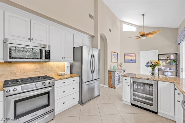 172 Via Napoli, Naples, FL 34105 - kitchen with stainless steel appliances, wine cooler, tasteful backsplash, high vaulted ceiling, and white cabinets