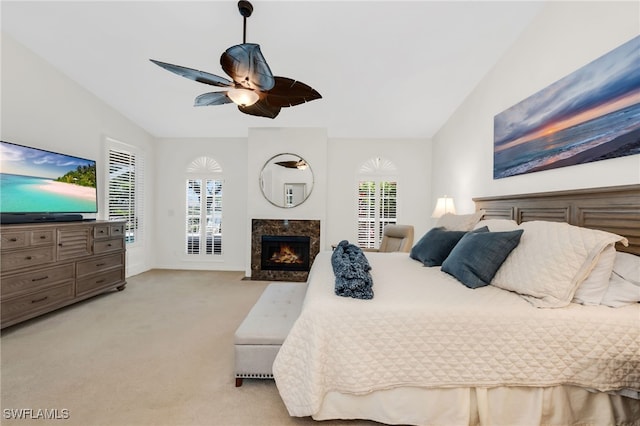 172 Via Napoli, Naples, FL 34105 - bedroom featuring light carpet, lofted ceiling, ceiling fan, and a high end fireplace