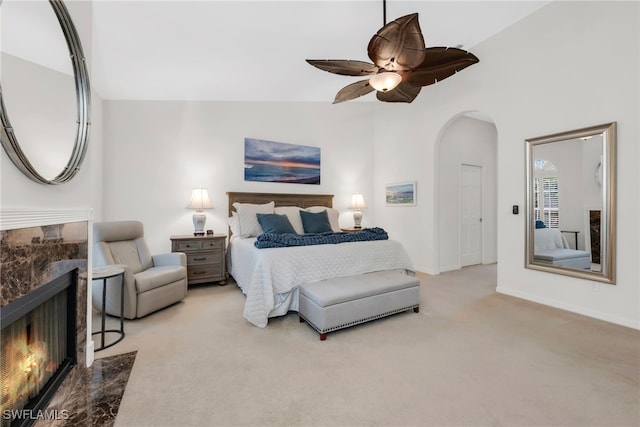172 Via Napoli, Naples, FL 34105 - bedroom featuring light colored carpet, arched walkways, a fireplace, baseboards, and lofted ceiling