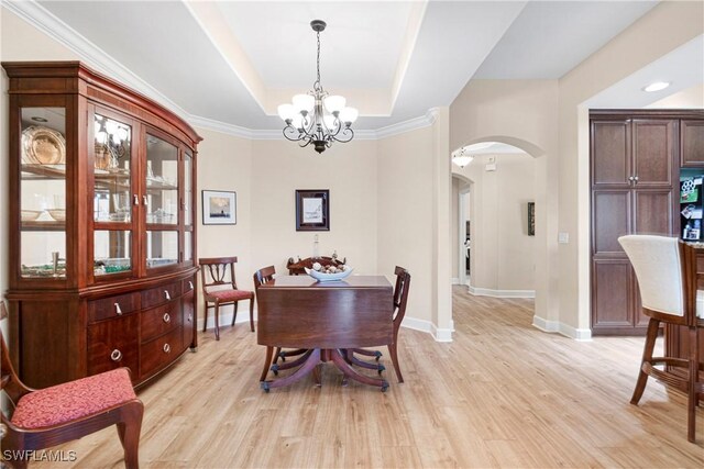 10644 Pelican Preserve Blvd # 101, Fort Myers, FL 33913 - dining area with an inviting chandelier, a raised ceiling, arched walkways, and light wood-style floors