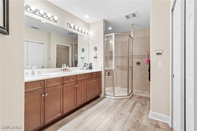10644 Pelican Preserve Blvd # 101, Fort Myers, FL 33913 - full bath with visible vents, double vanity, wood finished floors, a sink, and a stall shower